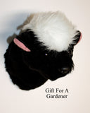 Plush skunk wall mount with  pink ear lining on a white background, labeled 'Gift For A Gardener'.